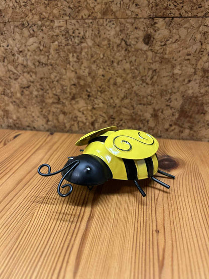 Gul bi figur i metal, set fra siden. De håndlavede detaljer og det stilrene udtryk giver en unik dekoration til hjem eller kontor.