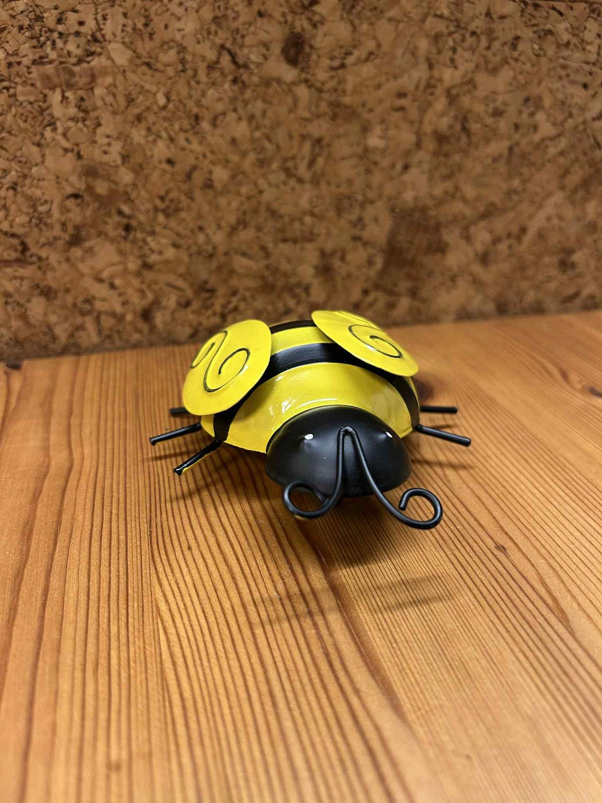 Dekorativ gul mariehøne i metal, set forfra. Fremhæver det unikke kunsthåndværk og den glatte gule overflade. Ideel til gave eller samlerobjekt