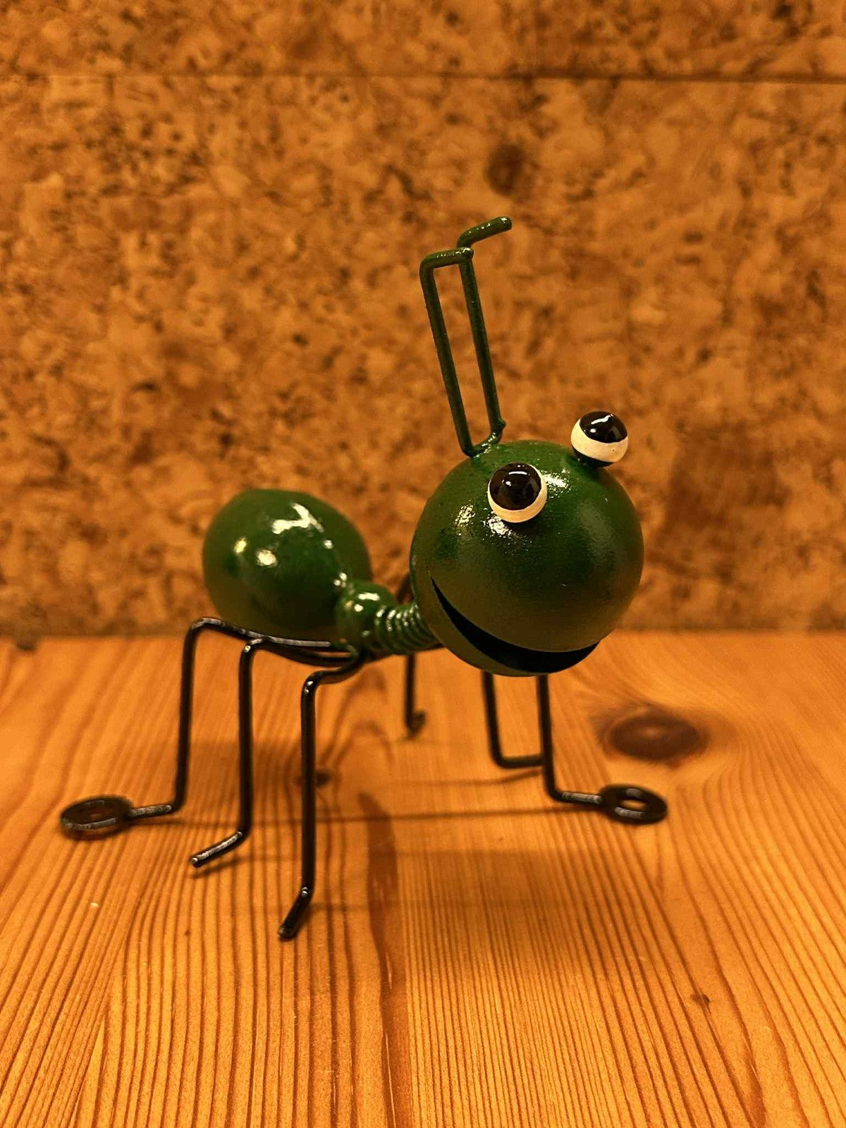 Grøn metal myre figur med store øjne, unik dekoration til bolig eller have.