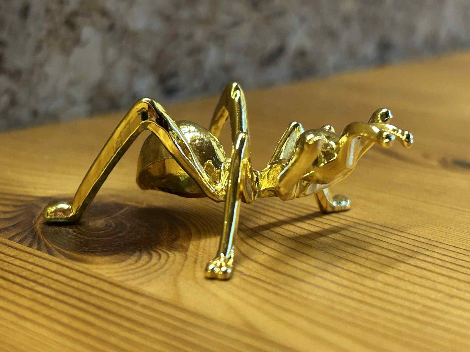 Dekorativ græshoppe figur i guld metal, perfekt til boligpynt, kontor og gave.