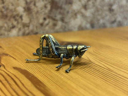 Dekorativ græshoppe figur i metal, unik insektfigur til boligindretning og samling.